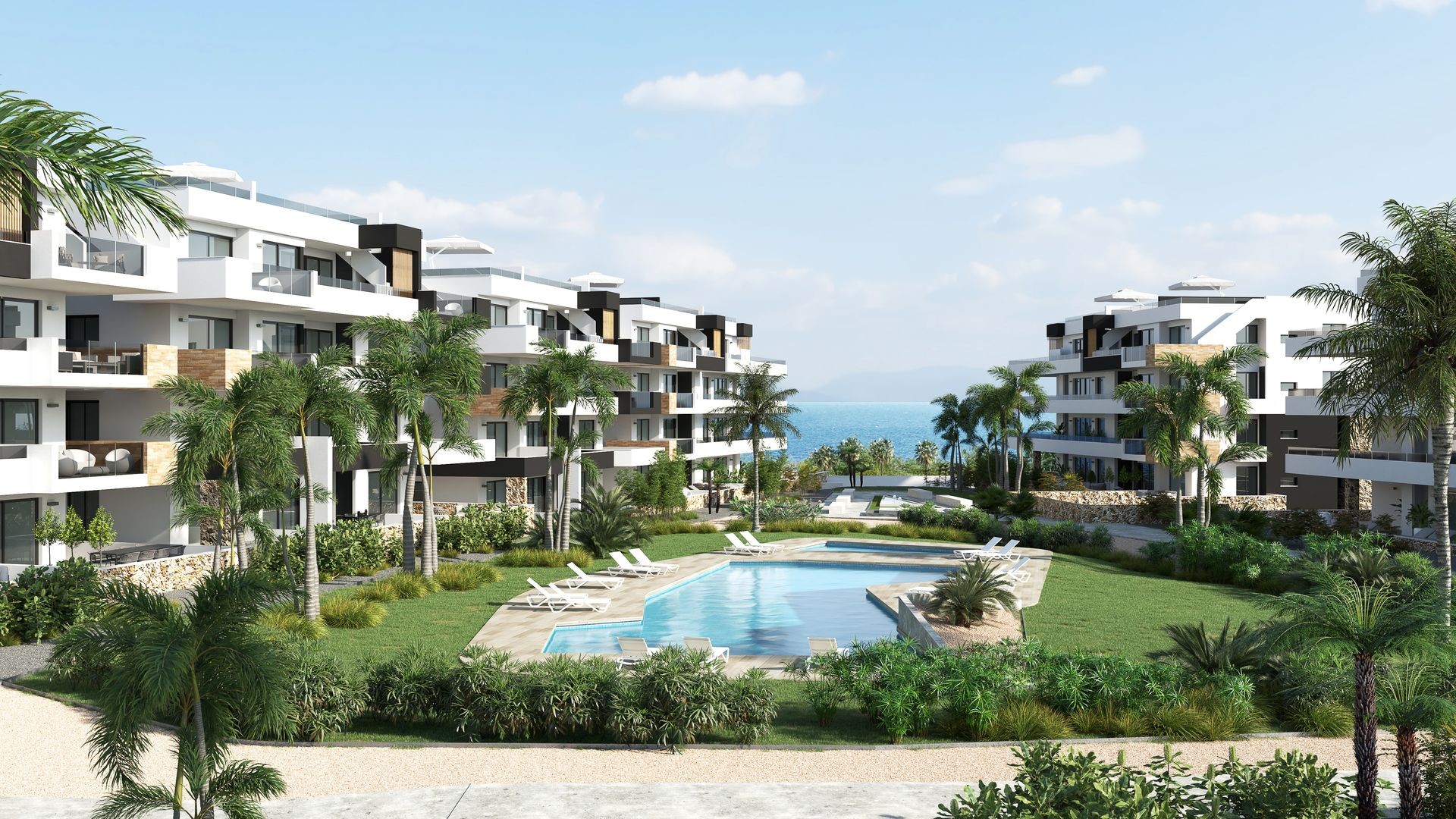 Modern apartment buildings with balconies surrounding a swimming pool and lush green garden, overlooking the sea.